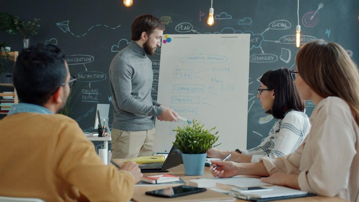 企業內訓講師與學員在白板前討論個人化學習規劃
