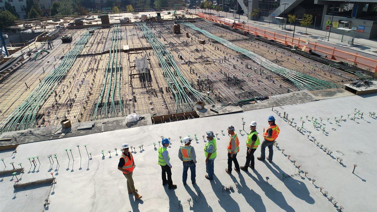 工程團隊戴著安全帽在施工現場進行跨部門技術協調與安全簡報